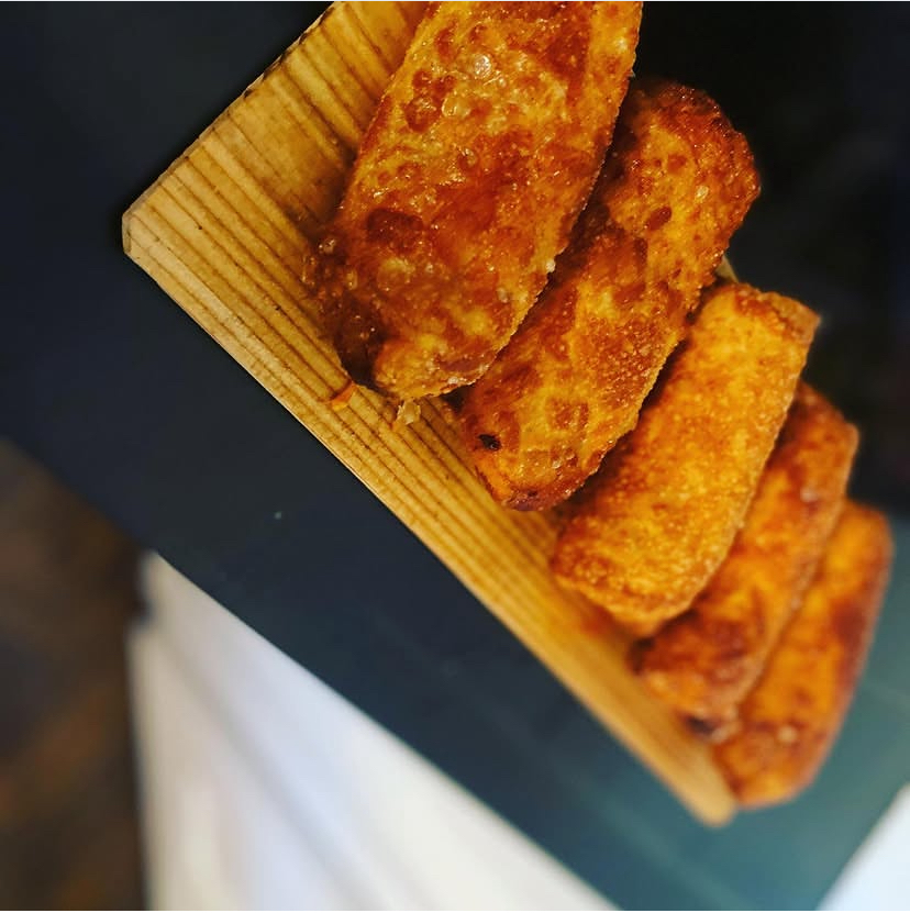 Golden crispy eggrolls served on a wooden board